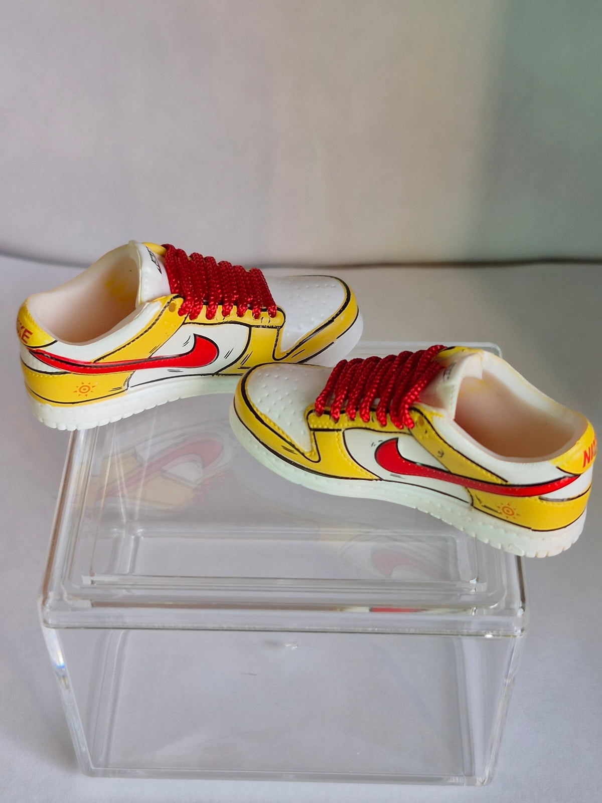 Yellow and White Cartoon Mini Sneakers with Red Swoosh – Collectible Pair with Display Case