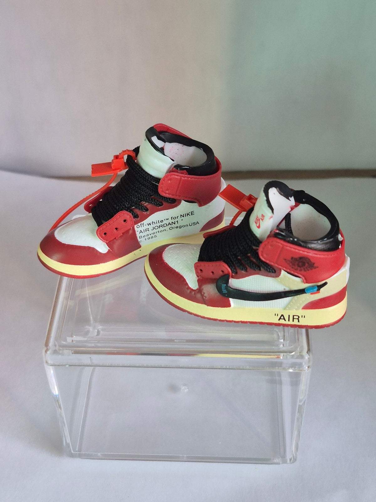 Red and white designer-style high-top mini sneakers, first view