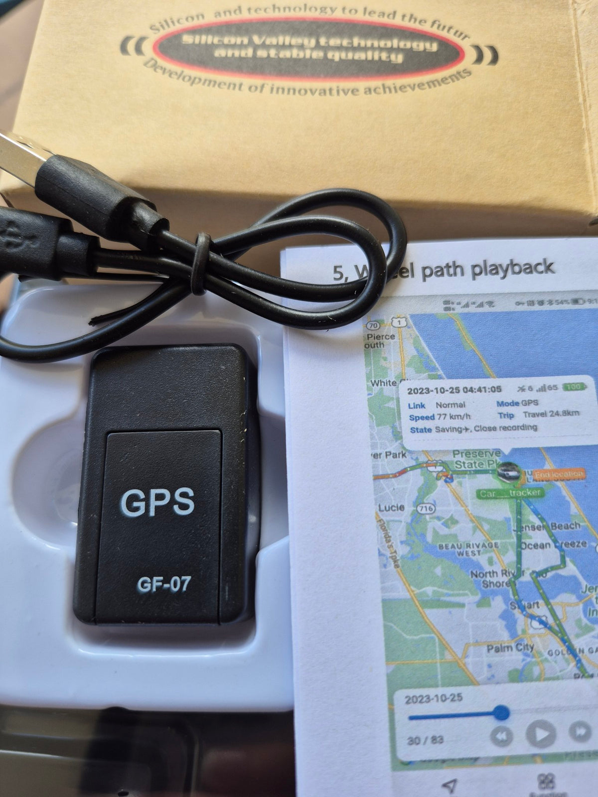 GF-07 GPS tracker close-up with manual
